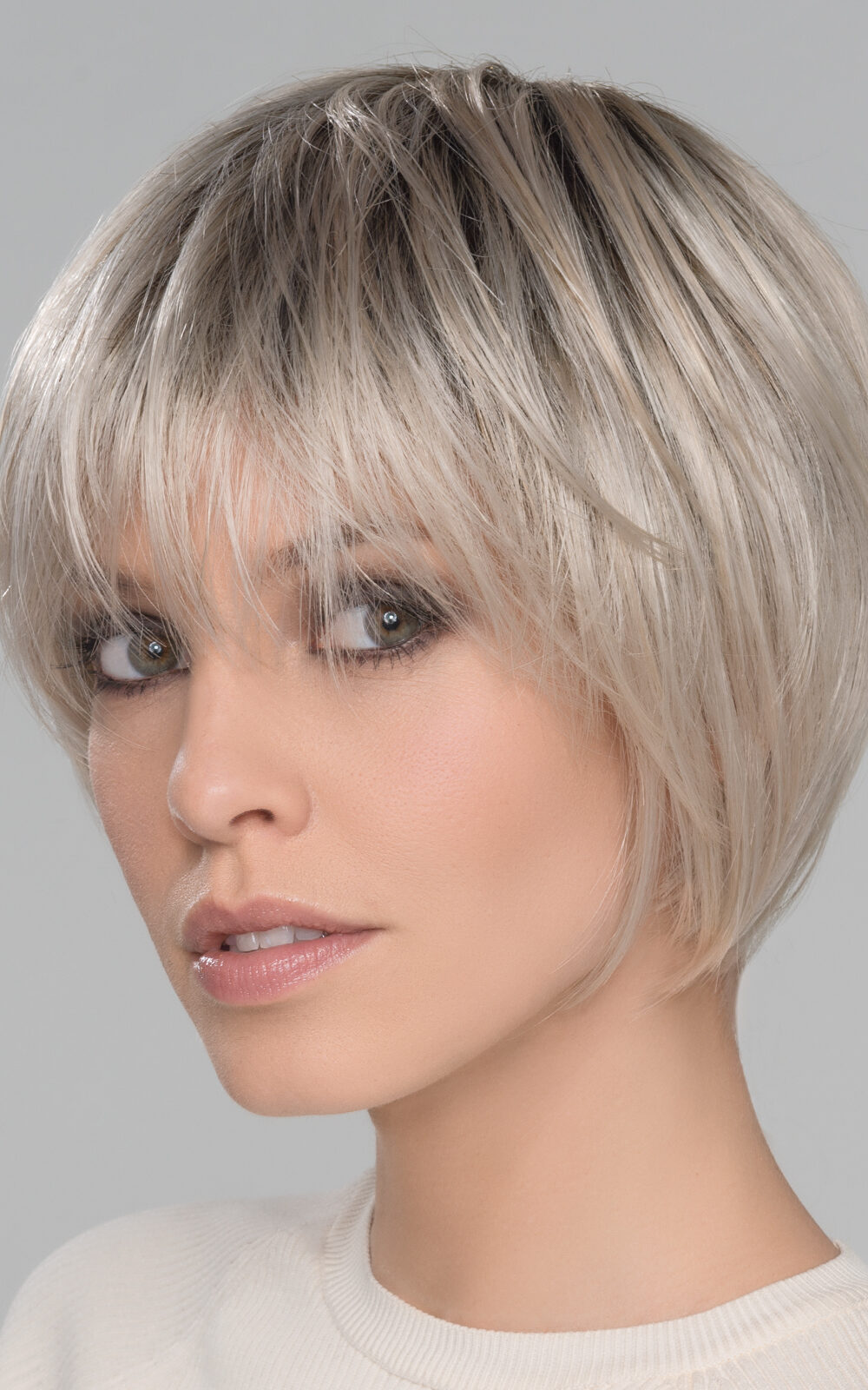 With soft layers that frame around the face. Edgy, with pieced out bangs and lots of personality