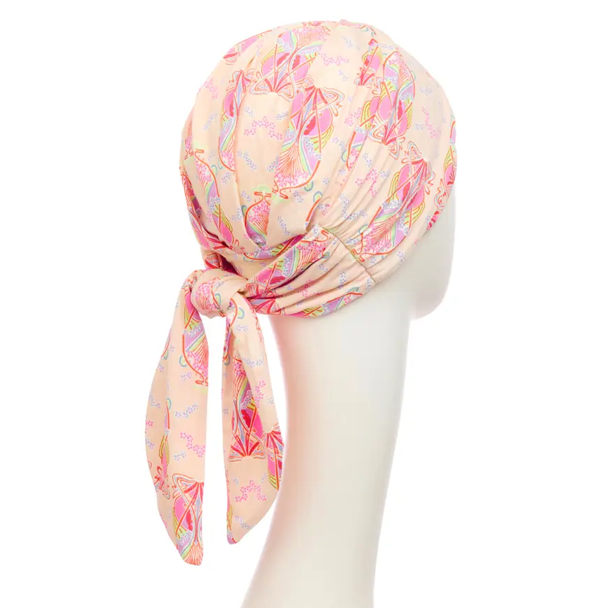 Meet the HocBeatrice Turban: Your Versatile Styling Companion! You're going to love the HocBeatrice turban! If you enjoy the feeling of ribbons at the nape of your neck and love having options, this versatile turban with its long ribbons is the perfect choice for you. The ribbons are fixed at the back, so you can easily tie them at your neck for a relaxed look, or, if you prefer a chic turban style, wrap them around your head to add beautiful extra volume! The HocBeatrice also boasts an excellent fit, and those elegant pleats at the back provide lovely fullness around your head. And here's a tip: you can always tie and style your HocBeatrice turban before you even put it on! Luxuriously Soft & Breathable Bamboo The HocBeatrice is crafted from our luxurious Caretech® bamboo-viscose material, which feels incredibly soft and silky against your skin. This stretchy, comfortable fabric is also wonderfully breathable, temperature-regulating, and more moisture-absorbent than cotton, ensuring exceptional comfort all day long, especially in the New Zealand climate! Vibrant Crocus Kaleidos Print You'll adore our Crocus Kaleidos print! It features a warm, cream base that truly comes alive with a kaleidoscope of pinks, purples, and greens, exuding a vibrant floral energy. On the HocShakti turban, the headband adds an extra touch of magic. One side showcases a mix of green, bold pink, and pastel cream, while the reverse side displays the stunning Crocus print itself. This gives you even more ways to style and express yourself! Typically ships within 1–2 business days. Certain colours may require additional time if temporarily out of stock, but rest assured, it’s well worth the wait.